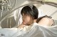 A woman laying on a bed with a cat ears headband.