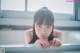 A young woman leaning on a window sill looking out the window.