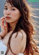 A woman with long brown hair is posing for a picture.