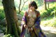 A naked woman in a kimono standing next to a tree.