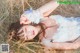 A woman laying in a field of tall grass.