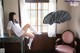 A woman sitting on top of a desk next to a window.