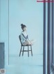 A woman sitting on a chair in a room.