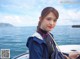 A woman in a blue jacket is sitting on a boat.